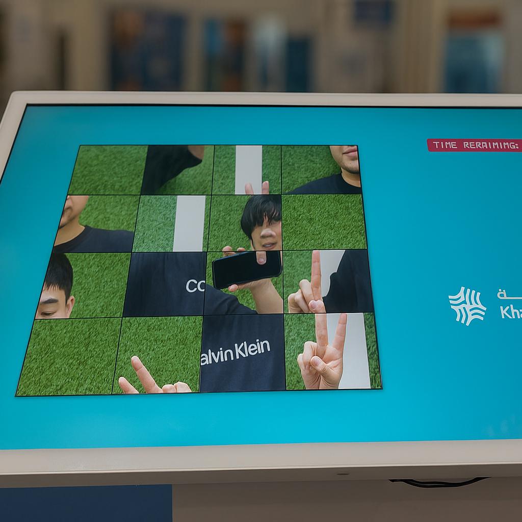 Guest solving a scrambled photo puzzle on a touchscreen at an event. Interactive image puzzle game rental for exhibitions, corporate events, and activations in Dubai.